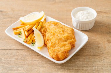 balık ve patates kızartması - kızarmış balık fileto patates cipsi ve limonlu beyaz tabak