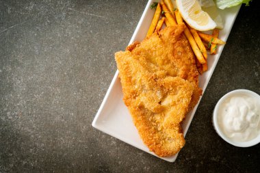 balık ve patates kızartması - kızarmış balık fileto patates cipsi ve limonlu beyaz tabak
