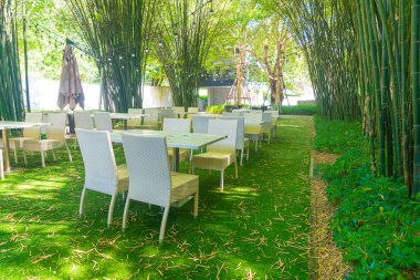 Boş hasır masa ve sandalye bambu bahçesi olan açık hava restoranında.