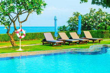 Havuz kenarındaki havuz, havuz, şemsiye, deniz manzaralı havuz tatilleri ve tatil konsepti.