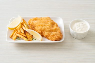 balık ve patates kızartması - kızarmış balık fileto patates cipsi ve limonlu beyaz tabak