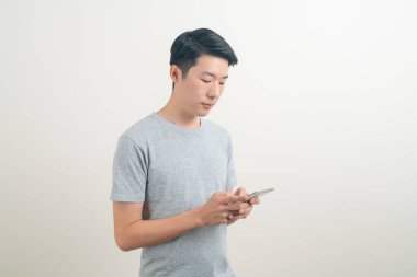 Beyaz arka planda akıllı telefon ve cep telefonu kullanan ya da konuşan genç Asyalı adam