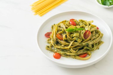 pesto soslu ve domatesli makarna vejetaryen ve vejetaryen yemek tarzı.