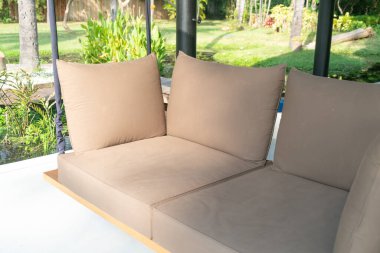 Boş kanepe dinlenmek için bahçede sallanıyor.