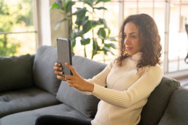 Latin kadın görüntülü ya da video konferans tablet üzerinde mutlu bir duygu ile
