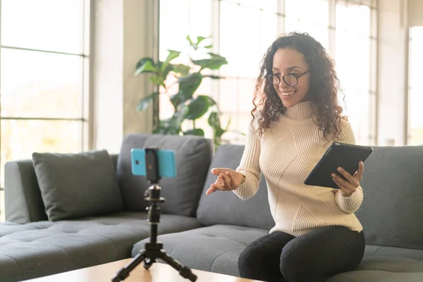 Latin kadın etkileyicisi video çekiyor ve blog için kamerayla konuşuyor - çevrimiçi içerik kavramı