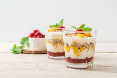 Ev yapımı taze mango ve yoğurt ve granola ile taze ahududu. Sağlıklı yemek tarzı.