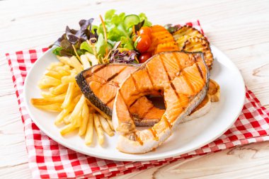 Çift ızgara somon bifteği, sebze ve patates kızartması.