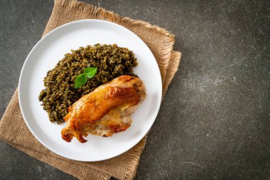 Kızarmış pesto pilavı ve beyaz tabakta kızarmış tavuk.