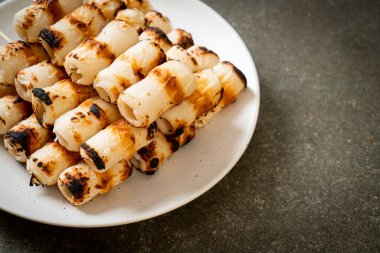 Izgara tüp şeklinde balık ezmeli kek ya da tabakta mürekkep balığı şişi.