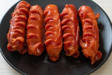 Siyah tabakta kızarmış sosis şişi.