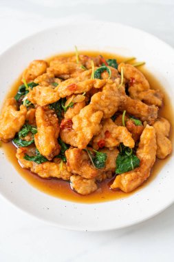 Tayland usulü fesleğen ve biberli kızarmış balık. Asya usulü.