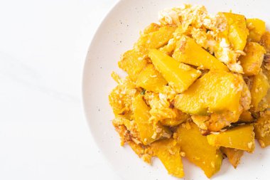 Beyaz tabakta yumurtalı kızarmış balkabağı.