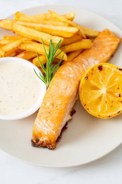 Limonlu kızarmış somon balığı ve patates kızartması.