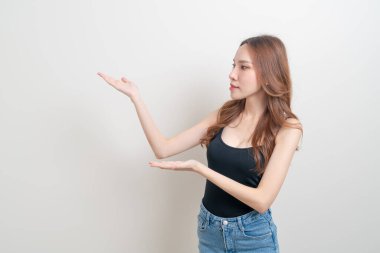 Güzel Asyalı kadın portresi beyaz arka planda el sallıyor ya da işaret ediyor.