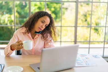 Latin kadın kahve fincanıyla çalışıyor.