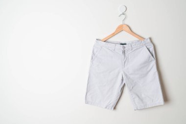 Kısa pantolon duvarda ahşap bir askıyla asılı.