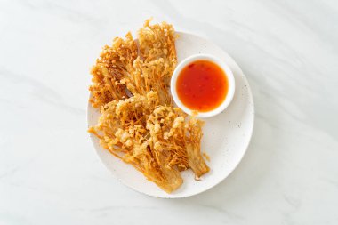 Kızarmış enoki mantarı ya da baharatlı soslu altın iğneli mantar - vejetaryen yemek tarzı.