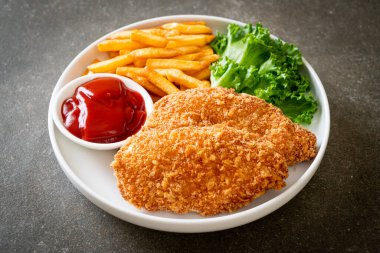 Kızarmış tavuk göğsü fileto biftek yanında patates kızartması ve ketçap.