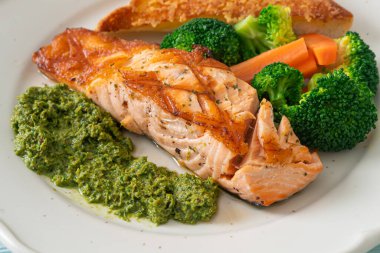 Pesto soslu ve sebzeli ızgara somon bifteği.