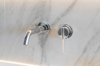 Lüks banyo odasındaki gümüş musluk.