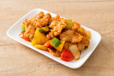 Kızarmış tatlı ve ekşi sosla domuz ve sebzeyi karıştır.