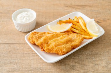 balık ve patates kızartması - kızarmış balık fileto patates cipsi ve limonlu beyaz tabak