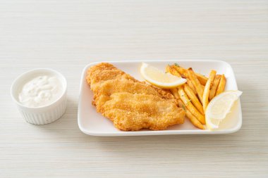 balık ve patates kızartması - kızarmış balık fileto patates cipsi ve limonlu beyaz tabak