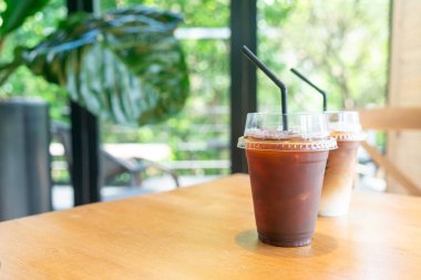 Kafe restoranının masasında kahve bardağında buzlu Americano kahvesi.