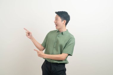 Beyaz arka planda eli işaret eden ya da sunan genç Asyalı adam portresi