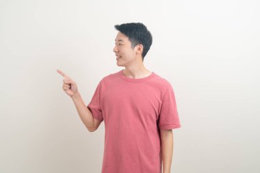 Beyaz arka planda eli işaret eden ya da sunan genç Asyalı adam portresi
