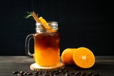Bir bardak buzlu americano sade kahve ve biberiye ve tarçınla süslenmiş portakal ve limon suyu.