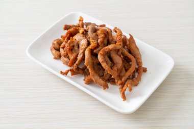 Beyaz tabakta kurutulmuş domuz eti, Asya yemeği tarzı.