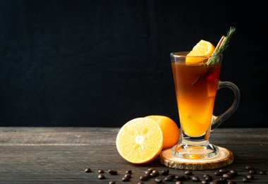 Bir bardak buzlu americano sade kahve ve biberiye ve tarçınla süslenmiş portakal ve limon suyu.
