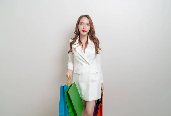 肖像画美しいアジアの女性が白い背景にショッピングバッグを保持 — ストック写真