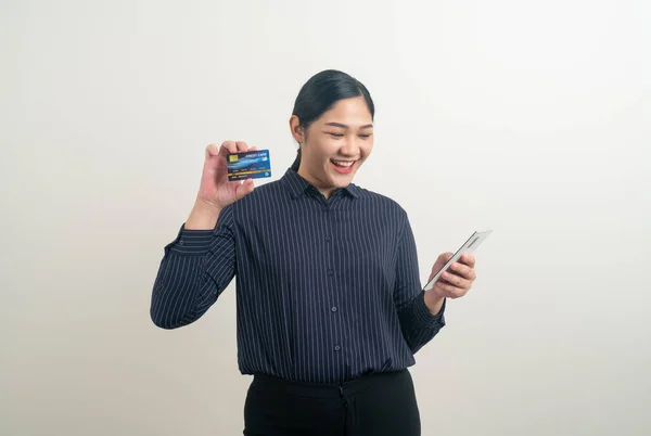 亚洲妇女使用手持白底信用卡的智能手机 — 图库照片