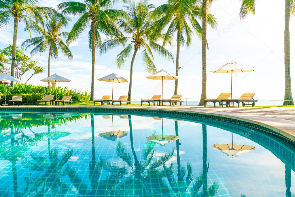 Beautiful umbrella and chair around swimming pool in hotel and resort - vacation concept