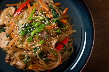 Japchae ya da karışık Kore vermicelli erişte sebzeli ve üzerine beyaz susamlı domuz eti - Kore geleneksel yemek tarzı