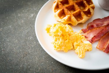 Kahvaltı için çırpılmış yumurta, pastırma ve waffle.