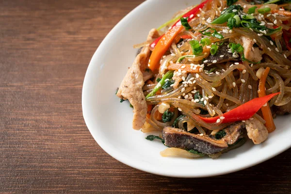Japchae ya da karışık Kore vermicelli erişte sebzeli ve üzerine beyaz susamlı domuz eti - Kore geleneksel yemek tarzı