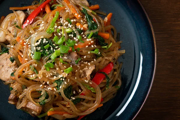 Japchae ya da karışık Kore vermicelli erişte sebzeli ve üzerine beyaz susamlı domuz eti - Kore geleneksel yemek tarzı