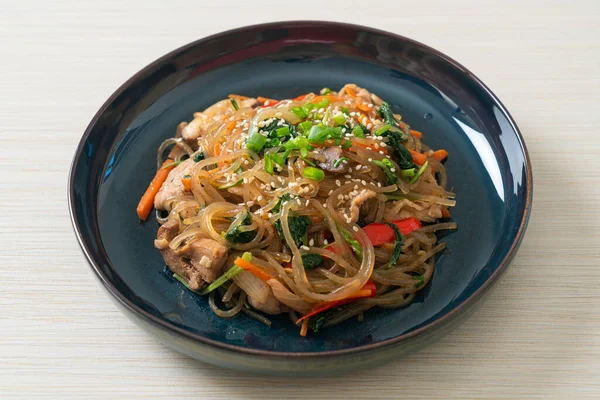白ゴマの上に野菜と豚肉をのせた日本風または炒め物の韓国の春雨麺 韓国の伝統料理 — ストック写真