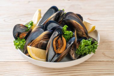 Limonlu bir kasede otlu taze midyeler.