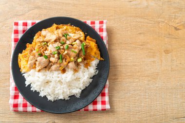 Pirinç üzerine sarımsak ve yumurta soslu kızarmış domuz eti. Asya usulü.