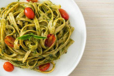 pesto soslu ve domatesli makarna vejetaryen ve vejetaryen yemek tarzı.