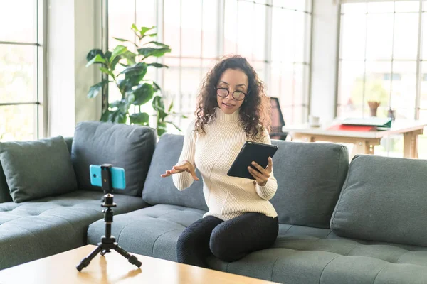 Latin kadın etkileyicisi video çekiyor ve blog için kamerayla konuşuyor - çevrimiçi içerik kavramı