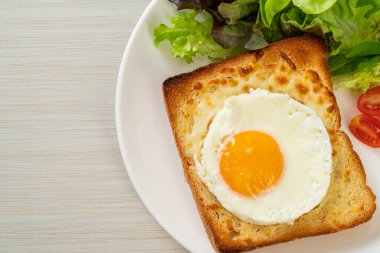 Peynirli ev yapımı ekmek ve kahvaltıda sebze salatasıyla birlikte kızarmış yumurta.