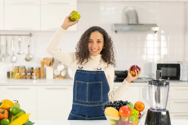 Latin kadın, vejetaryen yemeği için mutfakta meyve suyu yapıyor.