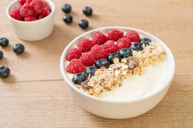 Ev yapımı yoğurt kasesi, ahududu, yaban mersini ve granola. Sağlıklı yemek tarzı.