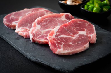 Taze domuz boyunlu ya da yakalı domuz eti ve terbiye edilecek malzemeler.